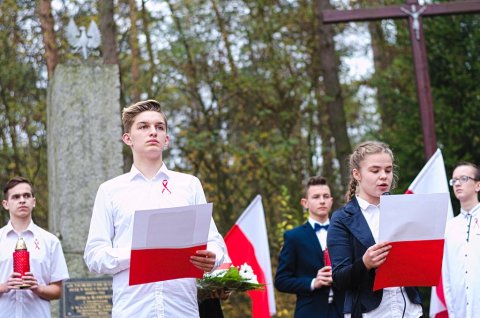 Uczniowie oddziałów gimnazjalnych Szkoły Podstawowej w Bierzwiennej Długiej przed pomnikiem w Nowinach Brdowskich